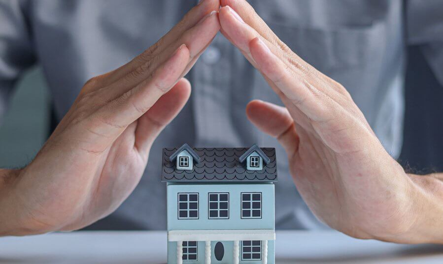 man protecting model house with hands over table 2026 06 29 20 33 25 utc 1