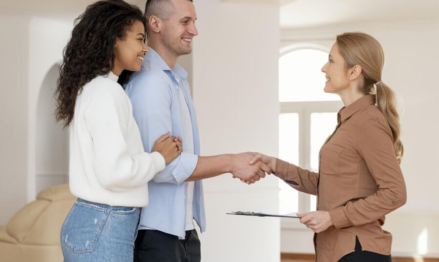 side view female realtor shaking hands with couple new house deal